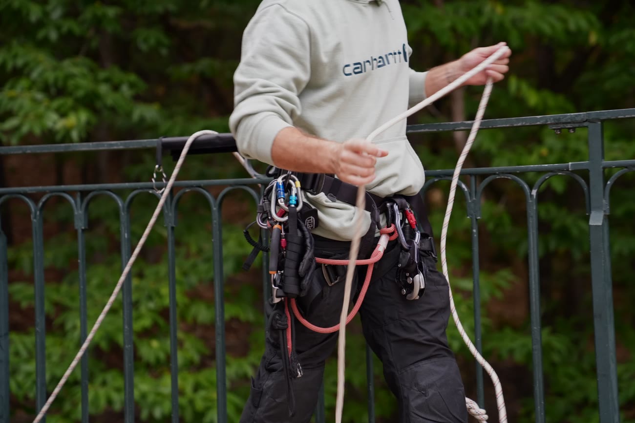 Cordiste lovant une corde au garde-corps d’un viaduc